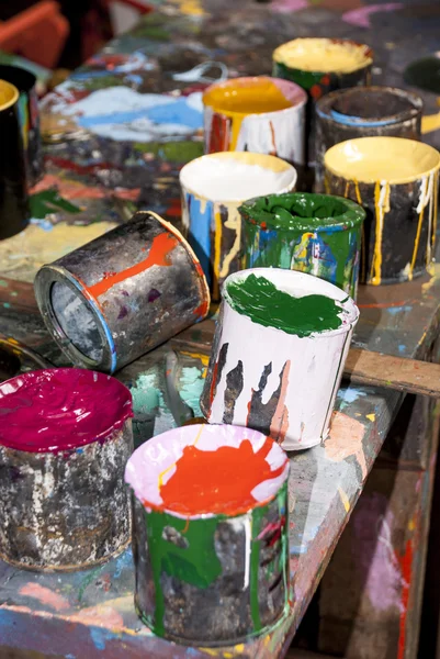 Paint bottles, brushes and paint cans