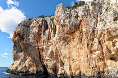 Mavi denizde ve İtalya 'nın Sardunya' nın doğu kıyısındaki Orosei körfezinde kayalık sahillerde geziniyorum. 20 Mayıs 2019