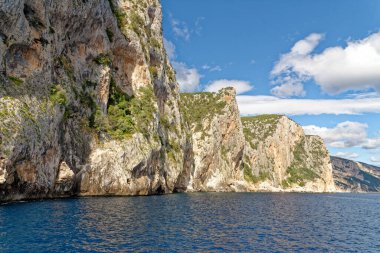Mavi denizde ve İtalya 'nın Sardunya' nın doğu kıyısındaki Orosei körfezinde kayalık sahillerde geziniyorum. 20 Mayıs 2019