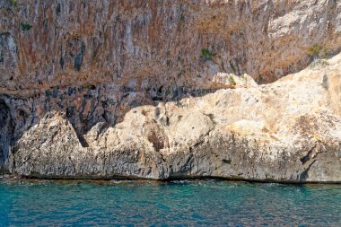 Mavi denizde ve İtalya 'nın Sardunya' nın doğu kıyısındaki Orosei körfezinde kayalık sahillerde geziniyorum. 20 Mayıs 2019