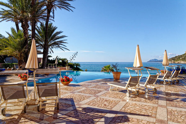 View of the pool and the Mediterranean sea in a sunny day - Holiday, Travel Destination - Arbatax, Sardinia, Italy - 18th of May 2019