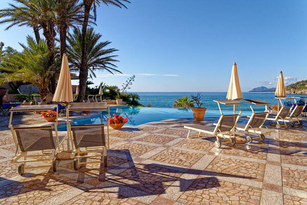 View of the pool and the Mediterranean sea in a sunny day - Holiday, Travel Destination - Arbatax, Sardinia, Italy - 18th of May 2019