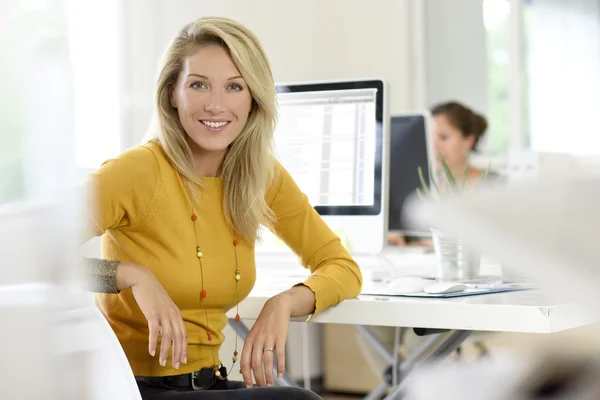 Donna bionda sorridente in ufficio — Foto Stock