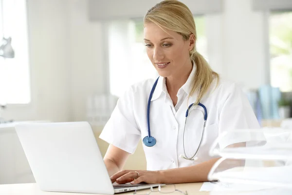 Doctor in office working on laptop — Stock Photo, Image
