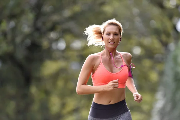 Mujer atlética corriendo en el bosque —  Fotos de Stock