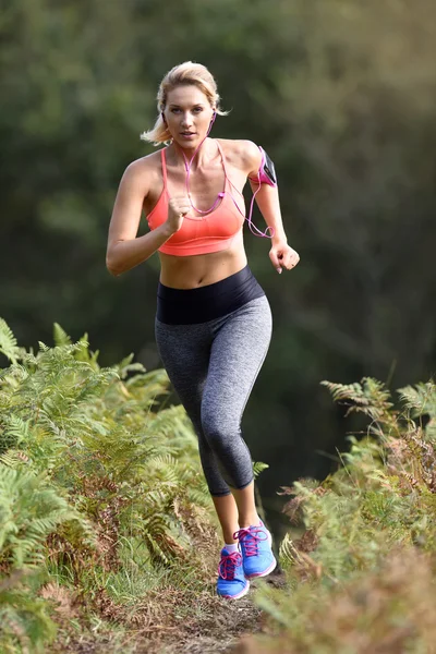 Athletic woman running in forest — Stock Photo, Image
