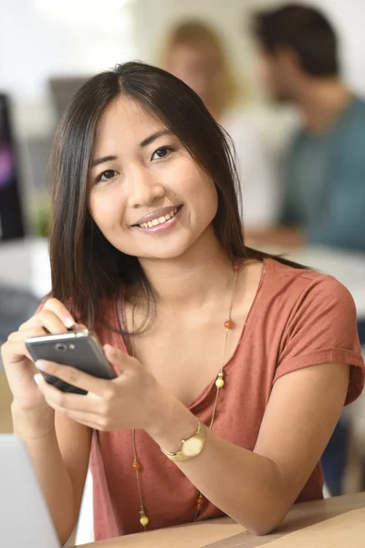 Mulher no escritório usando smartphone — Fotografia de Stock