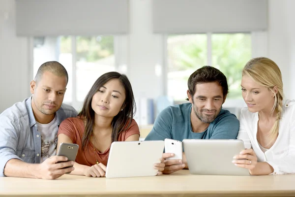 Personas que se reúnen con tabletas y smartphones — Foto de Stock