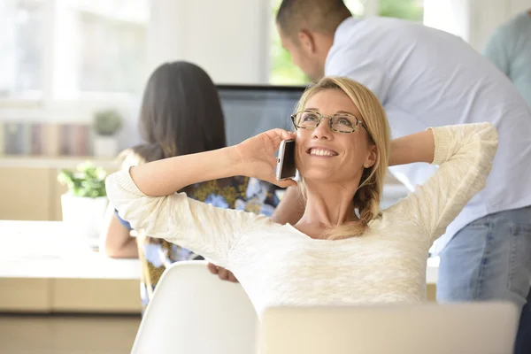 Vrouw in kantoor praten over telefoon — Stockfoto