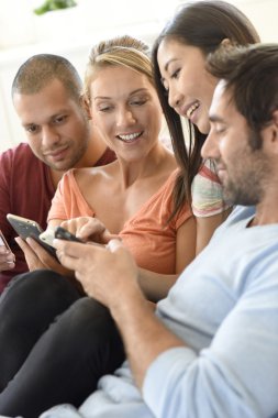 Arkadaşlar evde akıllı telefonlar ile oynamak