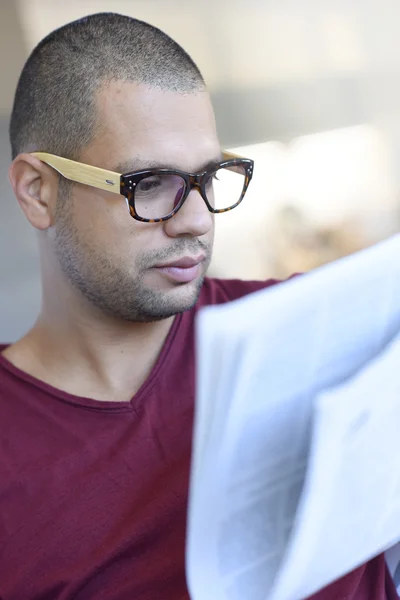 Парень в очках читает газету — стоковое фото