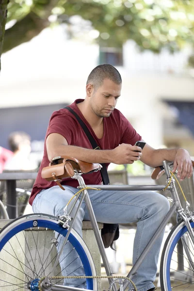 Человек с велосипедом сидит — стоковое фото