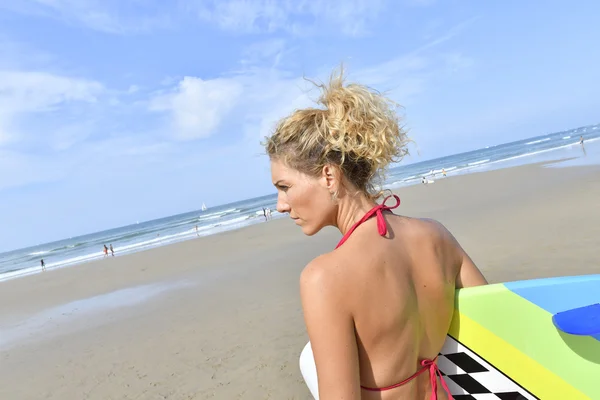 Surfer girl holding surfboard — Stock Photo, Image