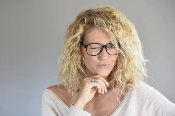 Femme blonde avec des lunettes clin d'oeil — Photo