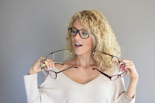 Mulher escolhendo entre diferentes óculos — Fotografia de Stock
