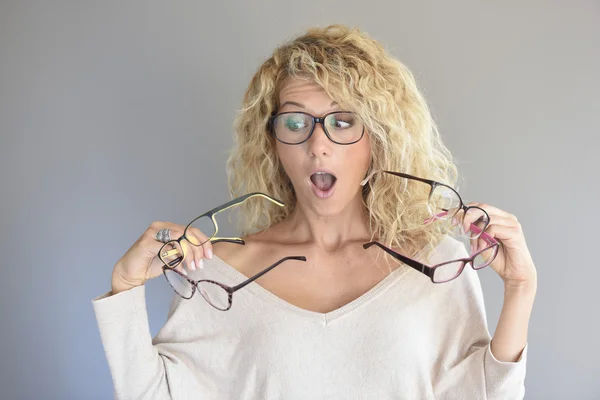 Woman  choosing between different eyeglasses — Φωτογραφία Αρχείου