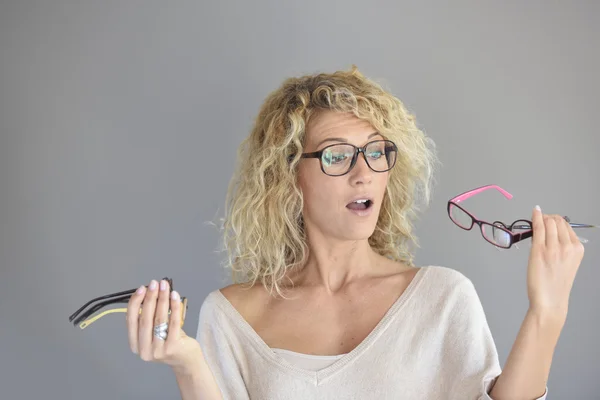 Женщина выбирает между различными очками — стоковое фото