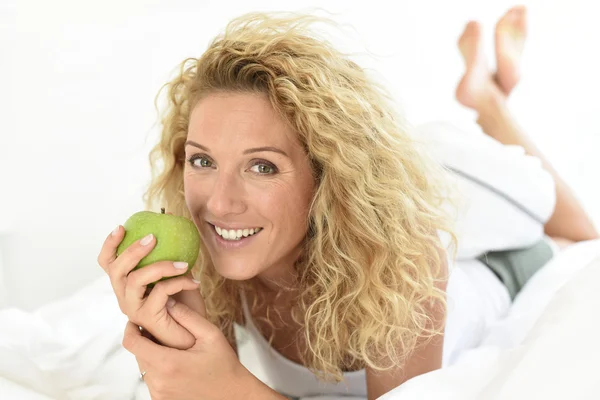 Žena jí zelené jablko — Stock fotografie