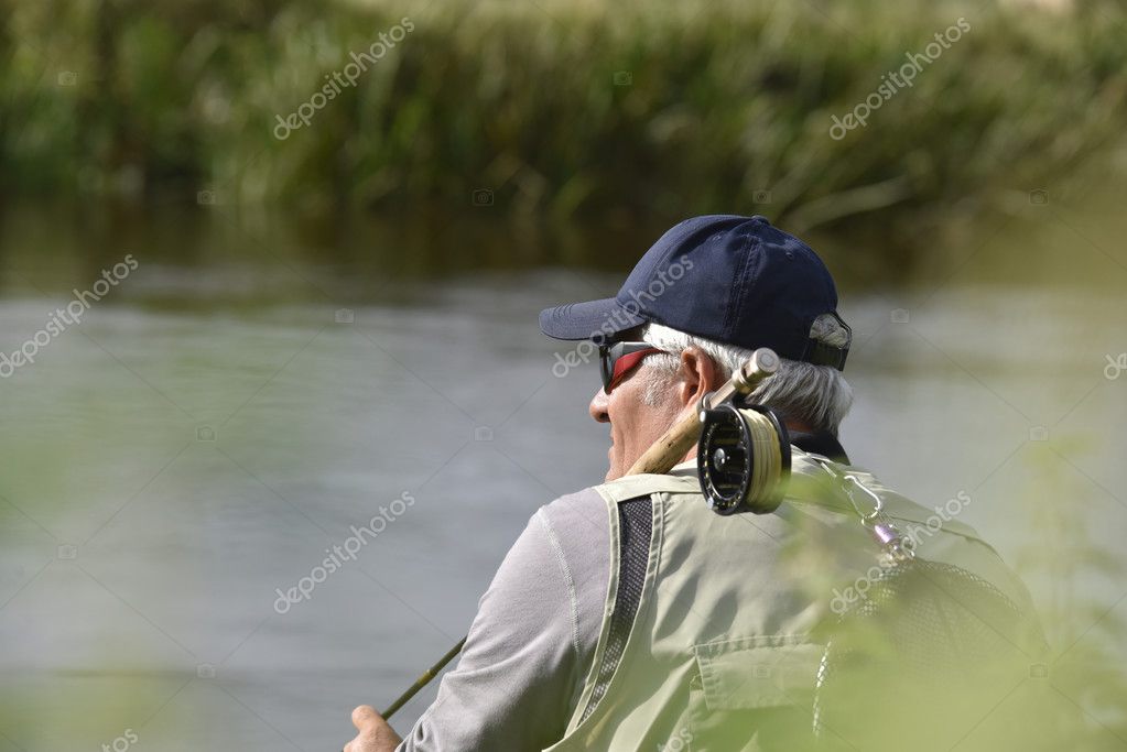 Fly-fisherman waiting with fishing pole — Stock Photo © Goodluz #128226888