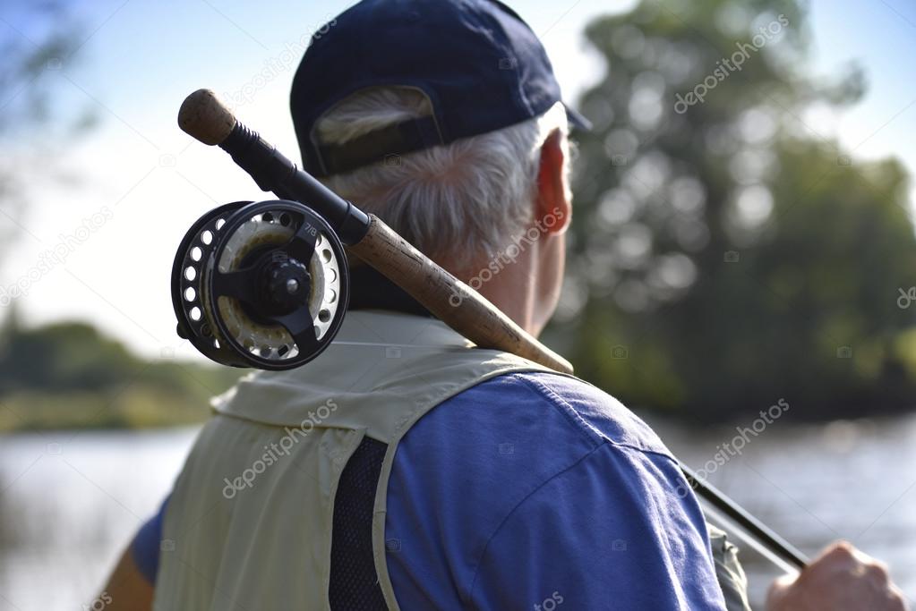 Fly-fisherman waiting with fishing pole
