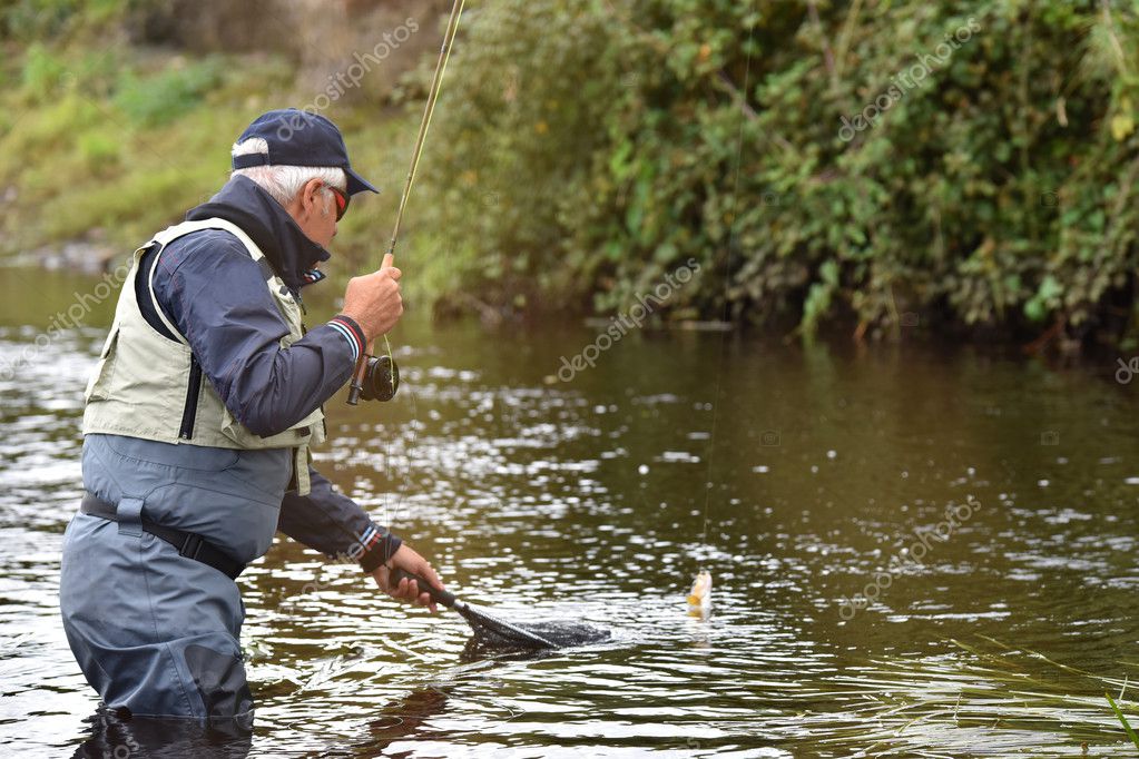 Flyfisherman catching trout — Stock Photo © Goodluz 128228284