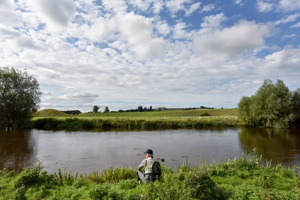 Pescatore in attesa sulla riva del fiume — Foto Stock