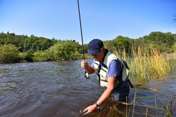 Pêcheur capture truite de mer — Photo