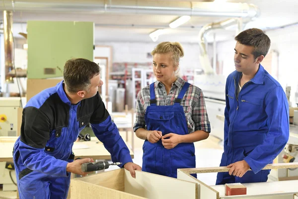 Carpinteiro com estudantes em oficina — Fotografia de Stock