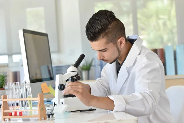 Student in biology using microscope — Stock Photo, Image