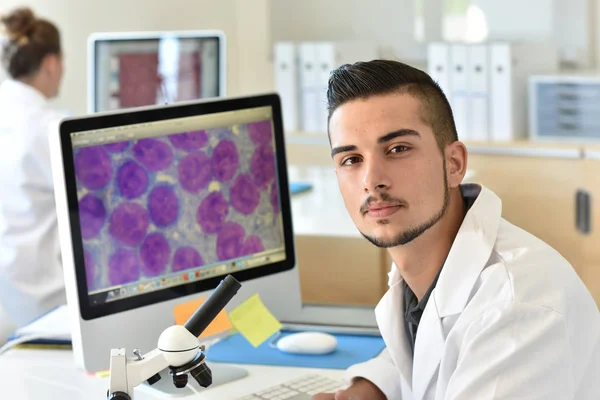 Student in biology using microscope — Stock Photo, Image