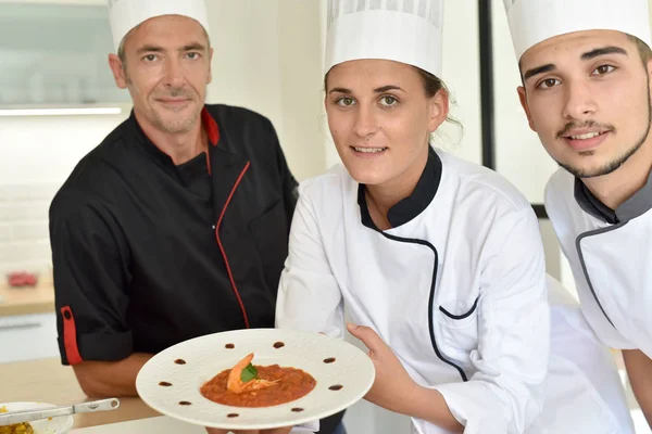 Chefs presenting dish to teacher — Stock Photo, Image