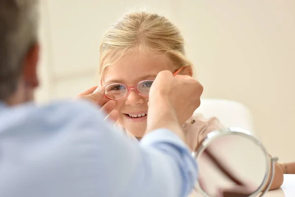 Mädchen beim Optiker probiert Brille aus — Stockfoto