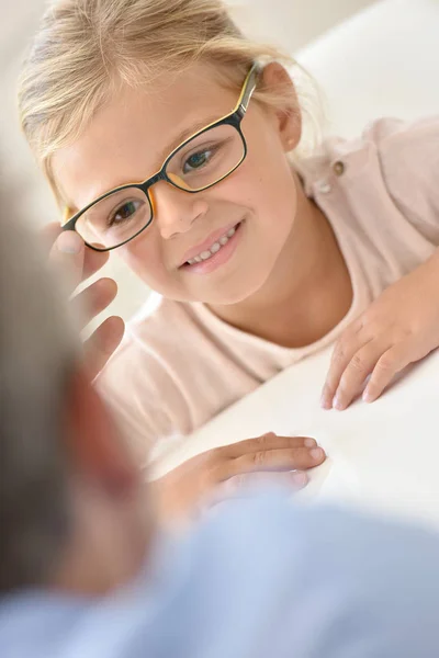 Chica en el óptico probando gafas — Foto de Stock