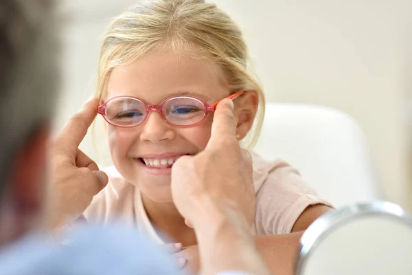 Flicka på optikern försöker glasögon — Stockfoto