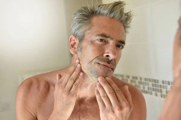 Homem no banheiro verificando barba — Fotografia de Stock