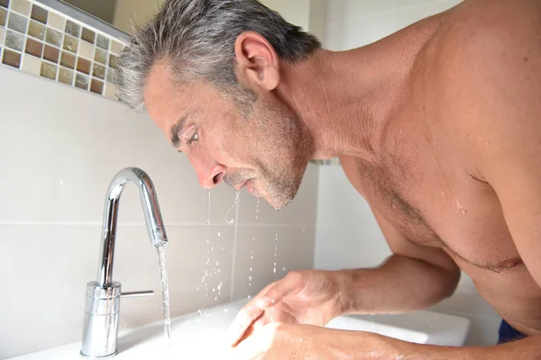 Mann wäscht sich im Badezimmer sein Gesicht — Stockfoto