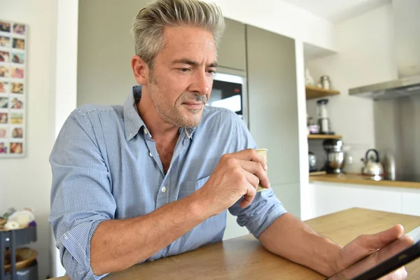 Homem em casa usando tablet digital — Fotografia de Stock