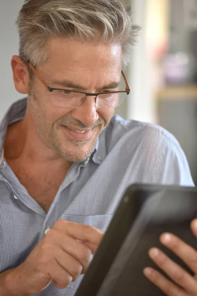 Homme mûr utilisant une tablette numérique — Photo