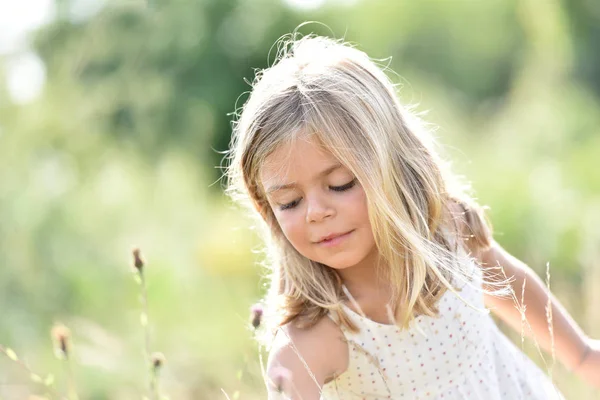 Blond tjej plocka blommor — Stockfoto