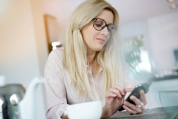 Mulher no escritório usando smartphone — Fotografia de Stock