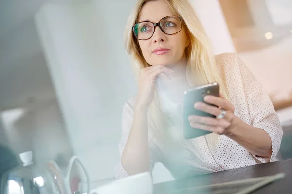 Frau im Büro mit Smartphone — Stockfoto