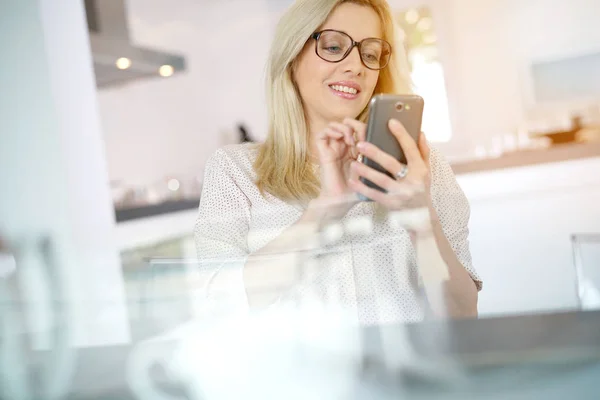 Mulher no escritório usando smartphone — Fotografia de Stock