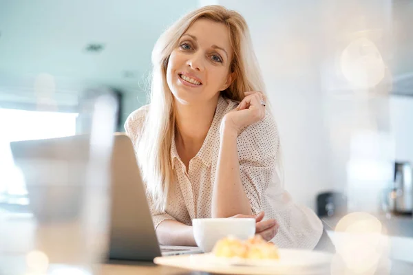 ノート パソコンの前でコーヒーを持つ女性 — ストック写真