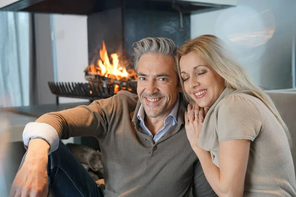 Pareja relajándose junto a la chimenea —  Fotos de Stock