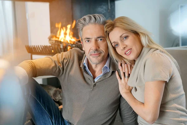 couple relaxing together by fireplace
