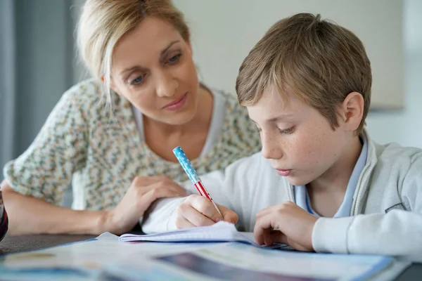 Donna aiutare figlio con i compiti — Foto Stock