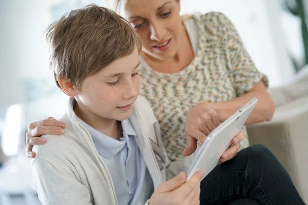 Moeder en zoon websurfing met tablet — Stockfoto