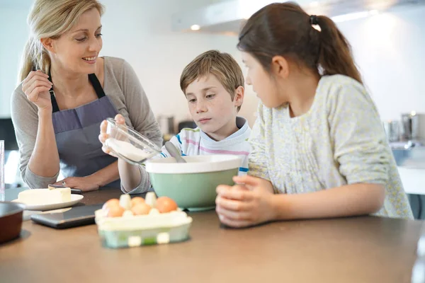 Mamma med barnen baka tårta — Stockfoto
