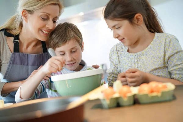 Mama met kinderen bakken taart — Stockfoto