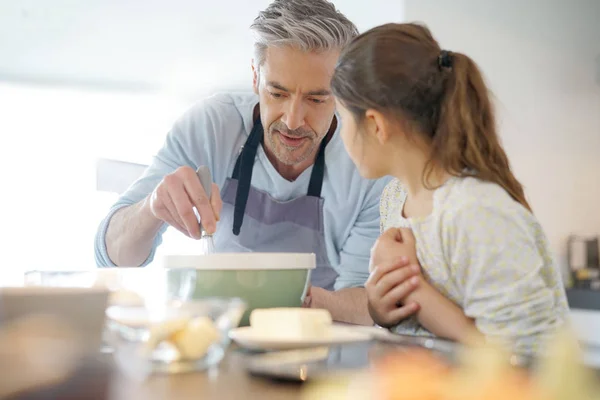 Daddy with daughter baking cake